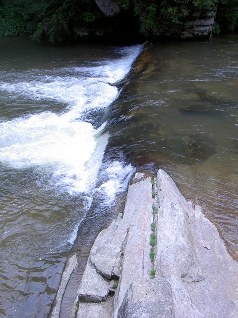 Water spilling out of the pool below the base of the falls.