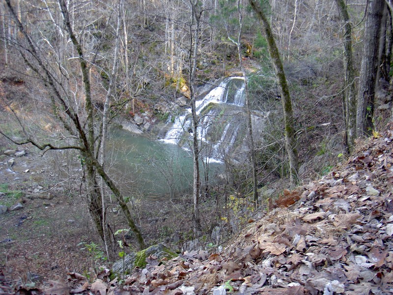 Joe Mill Creek Falls. Roadside at a very narrow gravel road. Concrete spillway where the creek flows over the road downstream.